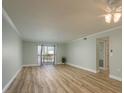 Open-concept living room featuring hardwood floors, neutral paint, ceiling fan, and sliding doors at 4904 38Th S Way # 316, St Petersburg, FL 33711