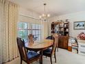 Elegant dining room with a wooden table, ornate chandelier, and large window at 4955 Grist Mill Cir, New Port Richey, FL 34655