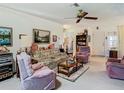 Inviting living room featuring a floral sofa, comfortable armchairs, and a ceiling fan at 4955 Grist Mill Cir, New Port Richey, FL 34655