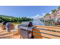 Outdoor grills with seating on a wooden dock overlooking calm waters and waterfront property at 5000 Culbreath Key Way # 1-310, Tampa, FL 33611