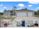 Charming single-story home with a well-manicured front yard, palm trees, and a spacious three-car garage at 5140 Eclipse Ct, Spring Hill, FL 34607