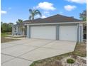 Charming single-story home with a three-car garage, lush landscaping, and a long, wide driveway at 5140 Eclipse Ct, Spring Hill, FL 34607