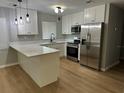 Modern kitchen featuring stainless steel appliances, white cabinetry, and an island with ample counter space at 6918 12Th N St, St Petersburg, FL 33702