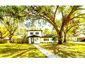 Beautifully landscaped front yard with a charming two-story home and mature trees at 708 15Th W Ave, Palmetto, FL 34221