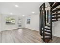 Open living area with wood floors, a spiral staircase, and natural light from windows and glass door at 708 15Th W Ave, Palmetto, FL 34221
