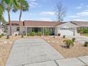 Charming single-story home with a brick facade, manicured landscaping, and a two-car garage in a sunny setting at 709 Flamingo Dr, Apollo Beach, FL 33572