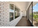 View of the screened front porch featuring brick walls, large windows, a concrete floor and access to the front door at 709 Flamingo Dr, Apollo Beach, FL 33572