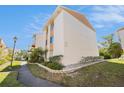 A side exterior view of the condo building shows well-maintained landscaping and building details at 9960 5Th St. N. # 304, St Petersburg, FL 33702
