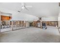 Open-concept living room with fireplace needing renovation, and ceiling fans, offering potential for customization at 120 Carlyle Cir, Palm Harbor, FL 34683