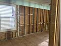 Interior of a room down to the studs and subfloor, with window at 19109 Gulf Blvd, Indian Shores, FL 33785