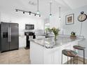 Modern kitchen with white cabinets, granite countertops, stainless steel appliances, and a breakfast bar at 2009 Sheffield Ct, Oldsmar, FL 34677