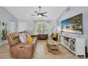 Cozy living room featuring a leather sofa, a colorful rug, and a large flat screen television at 2009 Sheffield Ct, Oldsmar, FL 34677