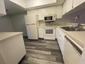 A bright kitchen features appliances, ample cabinet space, and a modern gray-tone floor at 2131 Ridge S Rd # 86, Largo, FL 33778