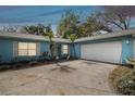 Charming home with a two-car garage, well-kept landscaping, and lush green trees at 22002 Darley Pl, Land O Lakes, FL 34639