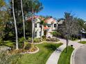 Well-manicured lawn and landscaping enhance this home's curb appeal on a sunny day at 2354 Messenger Cir, Safety Harbor, FL 34695