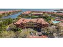 An aerial view of waterfront condos with boat docks and a pool overlooking a lake and ocean at 2709 Via Cipriani # 532B, Clearwater, FL 33764