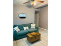 Cozy living room featuring a comfortable green couch with decorative pillows, a stylish mirror, and tiled flooring at 4108 55Th N Ave, St Petersburg, FL 33714