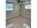 Cozy bedroom with tile flooring, natural light, and a ceiling fan at 5131 Greenwood St, New Port Richey, FL 34653