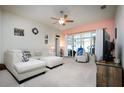 Comfortable living room features a ceiling fan, neutral carpet, and sliding glass doors to the backyard at 895 Sea Holly Dr, Brooksville, FL 34604