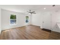 Bright living room with wood floors, natural light and a modern ceiling fan and front door at 10113 Huntley St, New Port Richey, FL 34654
