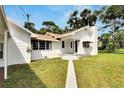 View of the home's front entry and landscaping, with a walkway leading to the entrance at 11718 N Ola Ave, Tampa, FL 33612