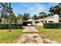 Single-story home with a driveway and carport at 11718 N Ola Ave, Tampa, FL 33612
