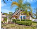 Charming single-story home with stone accents, well-manicured landscaping, and mature palms under a bright blue sky at 1307 Garden Stone Ln, Brandon, FL 33510