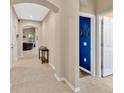 Light-filled hallway with neutral tile flooring, leading to arched doorways and offering a glimpse into the living space at 1307 Garden Stone Ln, Brandon, FL 33510
