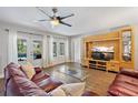 Relaxing living room boasts a ceiling fan, stylish furniture, and French door access to the pool at 1426 75Th Ne Cir, St Petersburg, FL 33702