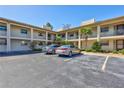 Exterior of a multi-unit condo building featuring a parking lot, landscaping, and balconies at 19029 Us Highway 19 N # 1-22, Clearwater, FL 33764