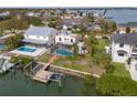 A beautiful aerial view of a home and backyard that features a dock, swimming pool, and green lawn at 1936 Arrowhead Ne Dr, St Petersburg, FL 33703