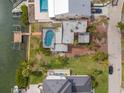 This aerial view showcases a waterfront property with a backyard pool, a dock, and mature landscaping at 1936 Arrowhead Ne Dr, St Petersburg, FL 33703