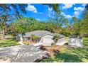 Inviting single-story home featuring lush landscaping, a spacious driveway, and a storage shed in the backyard at 19531 Deer Lake Rd, Lutz, FL 33548
