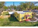 A high angle shows the back of the charming yellow home with an enclosed porch and new fencing at 2310 13Th W Ave, Bradenton, FL 34205