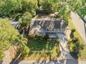 Aerial shot of a charming single-Gathering home with a large backyard, surrounded by lush greenery and mature trees at 2412 Giddens Ave, Seffner, FL 33584