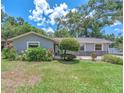A charming single-story home with a well-maintained lawn and mature landscaping, complemented by a stone accent wall at 2412 Giddens Ave, Seffner, FL 33584
