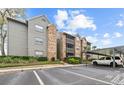 Exterior view of a condo complex with assigned parking, beautiful siding, and stairs to upper units at 2500 Winding Creek Blvd # E302, Clearwater, FL 33761