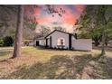 Charming single-story home featuring a freshly painted exterior, manicured lawn and white fence at 2887 North Rd, Clearwater, FL 33760