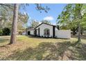Charming single-story home featuring a freshly painted exterior, manicured lawn and white fence at 2887 North Rd, Clearwater, FL 33760