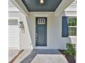 Inviting front entrance with a modern gray door, stylish lighting, and paved walkway at 3913 W Euclid Ave, Tampa, FL 33629