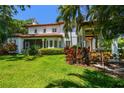 Expansive backyard with lush lawn, mature trees, and a covered patio, perfect for outdoor entertaining at 808 Idlewood Ave, Tampa, FL 33609