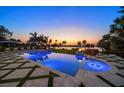 Stunning pool reflecting sunset colors, accompanied by stylish lounge chairs and fire bowls for a serene outdoor experience at 110 Harbor View Ln, Belleair Bluffs, FL 33770