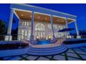 Luxury home with stately columns, a covered patio, and tiered yard with water feature and fire bowls at 110 Harbor View Ln, Belleair Bluffs, FL 33770