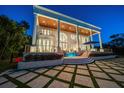 Luxury home with stately columns, a covered patio, and tiered yard with water feature and fire bowls at 110 Harbor View Ln, Belleair Bluffs, FL 33770