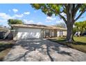 Paved driveway with an attached garage, shaded by a beautiful mature tree, offering ample parking at 1218 Lornewood Dr, Valrico, FL 33596