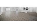 Open-concept living space with light laminate flooring, leading to a modern white kitchen at 1218 Lornewood Dr, Valrico, FL 33596