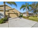 Charming home featuring a two-car garage, lush green bushes, and a vibrant green lawn at 2253 Oakley Green Dr # 26, Sun City Center, FL 33573
