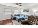 Spacious living room featuring a plush blue sectional, ceiling fan, and hardwood floors at 2626 36Th N Ave, St Petersburg, FL 33713