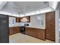 Well-lit kitchen with dark cabinetry, white countertops, black appliances, and a ceiling fan at 3210 Mcmath Dr, Palm Harbor, FL 34684