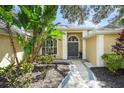 Beautiful home entrance featuring an elegant doorway framed by lush tropical landscaping at 5141 Sunnydale W Cir, Sarasota, FL 34233
